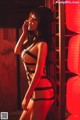 A woman in a black lingerie standing in front of red lanterns.