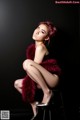 A woman sitting on top of a stool wearing a fur vest.